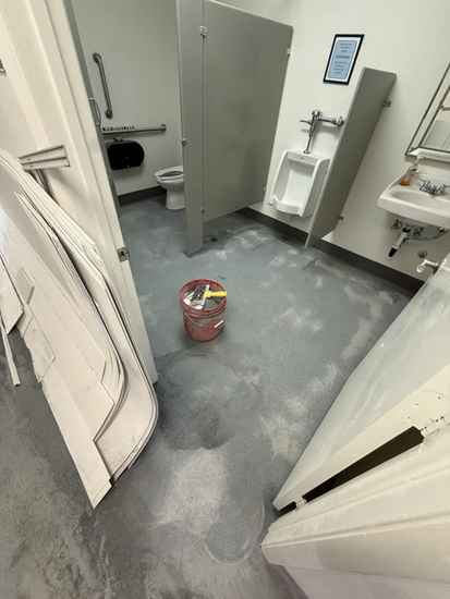 Commercial restroom floor during grinding and renovation prep